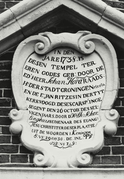Aan de voorkant van de kerk, boven de ingang prijkt dit bord waarop staat aangegeven dat Johan Hora, raadsheer van de Stad Groningen en kerkvoogd Jan ritzes de kerk in 1738 hebben laten bouwen. Deze werd ingezegend door Wilh. Schortinghuis op 26 oktober van hetzelfde jaar.